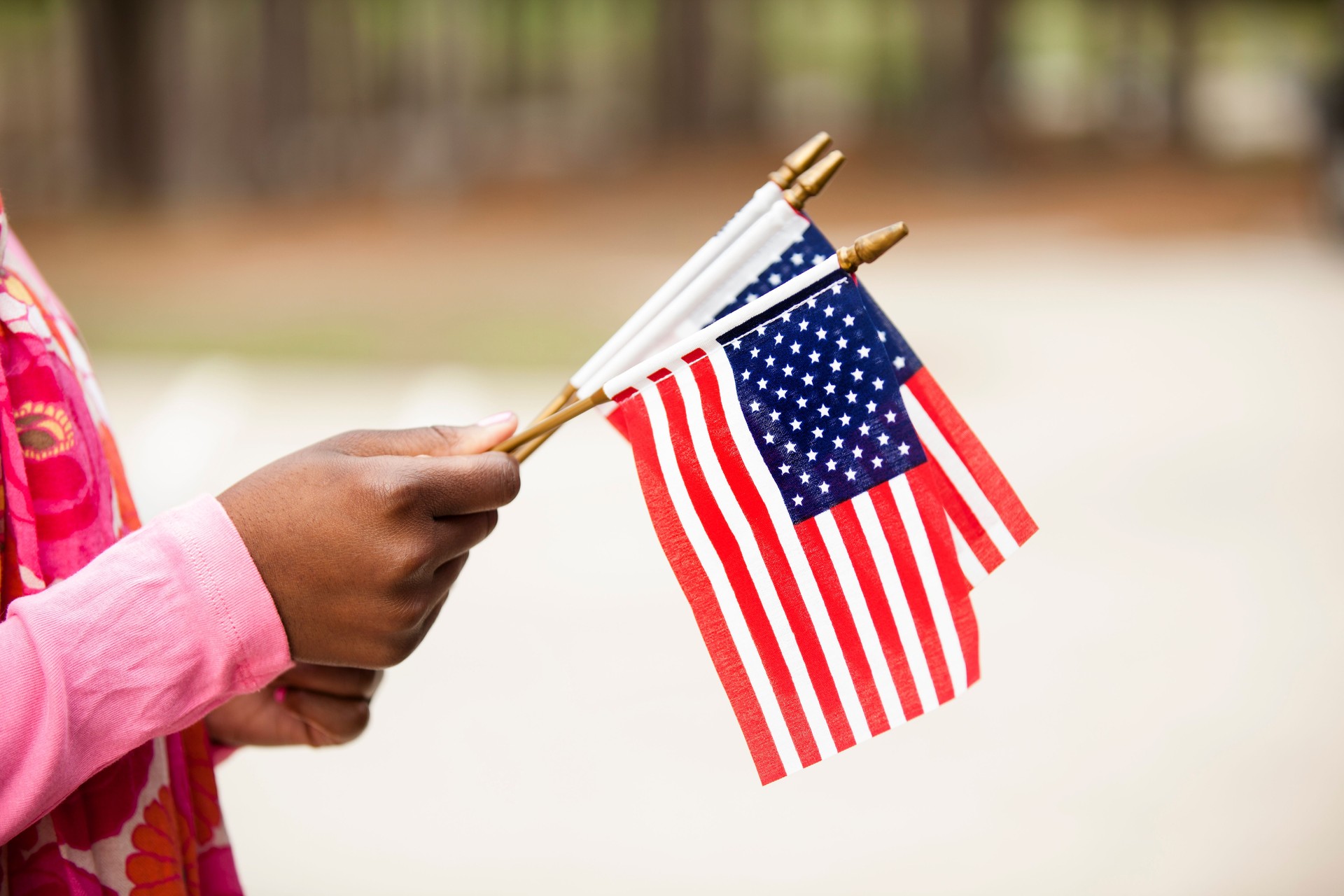African descent woman holding American flags.